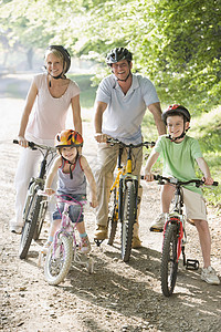 坐在路上微笑的自行车上的家庭图片