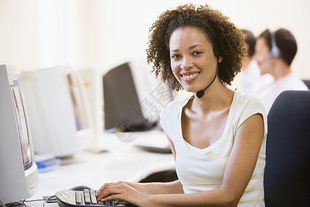 妇女在计算机室戴耳头巾的妇女微笑电脑室女性热线电脑水平办公室服饰通讯工人电话销售图片