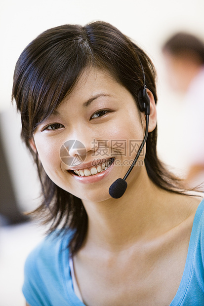 身戴头盔的妇女在室内微笑讨论人士商务求助耳机呼叫功率终端通讯操作员图片