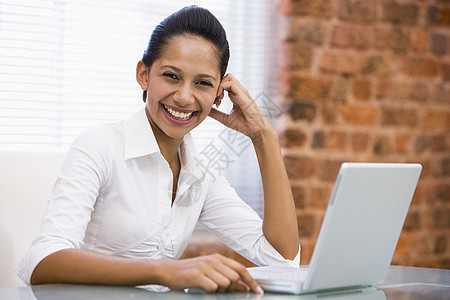 拥有笔记本电脑笑的现任女商务人士工作技术女士女子混血商务职场桌子人士水平图片