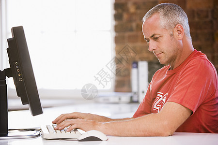 计算机办公室打字的商务人员男人中年技术职场男性人士终端桌子电脑服饰图片