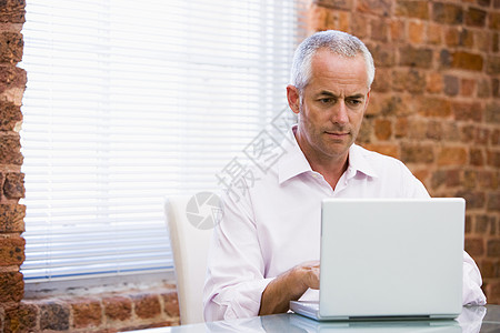 在办公室看笔记本电脑的商务人士技术商务男性服饰工作职场水平生意人微笑中年图片