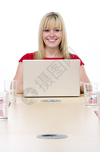 商业妇女带着笔记本电脑微笑坐在会议室的客厅里图片