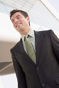 商务人士靠着微笑的建筑站在户外倾斜时间生意人偏移男人企业男性办公楼成人偏移角图片