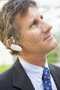 在户外佩戴耳机的商务人士讨论中年电话沟通婴儿头肩蓝牙男性生意人讲话图片
