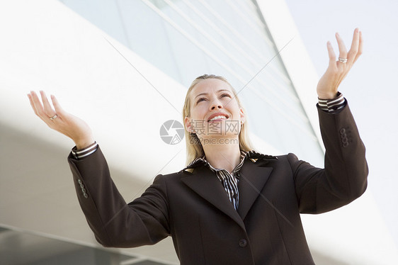 女商务人士站在户外 用手伸出微笑的手建起建筑图片