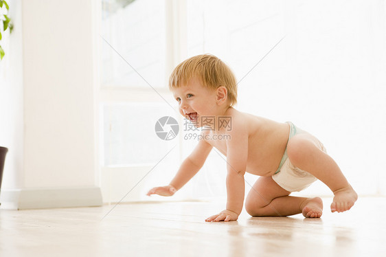 婴儿在室内爬动时微笑着笑容关爱幸福男性样子孩子孩子们男生小男孩水平图片