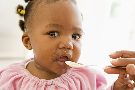 母亲喂婴儿食物给婴儿勺子女性家庭女孩享受头肩两个人健康饮食双手饮食图片