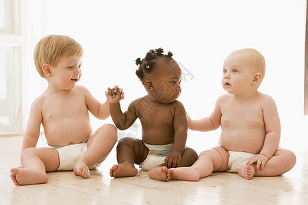 三个婴儿坐在室内 手握双手背景图片
