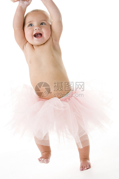 婴儿穿着礼裙站着女孩短裙奇装异服芭蕾舞戏服享受相机影棚演员乐趣图片