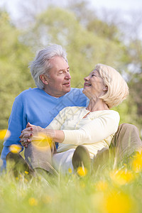 一对在户外放松的情侣微笑着退休女士农村相机妻子女性毛茛公园男性场地图片