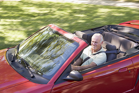 穿着可兑换汽车的男人微笑着敞篷车农村享受退休男性驾驶水平运动速度相机图片