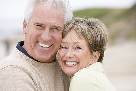 在海滩上笑着的情侣男人妻子亲热感情女性退休夫妻男性水平微笑图片
