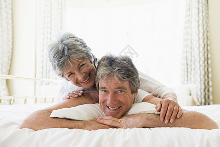 一对躺在床上的情侣 一起微笑地躺在床上感情两个人水平卧室苏醒夫妻妻子退休丈夫男性图片