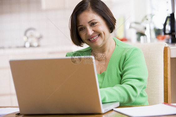 厨房里的女人带着笔记本电脑的微笑银色女士婴儿成人女性冲浪者拉丁技术水平互联网图片