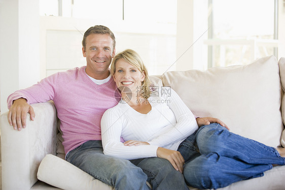 情侣在客厅放松 微笑长度女士男性沙发长椅亲密感丈夫妻子女性男人图片