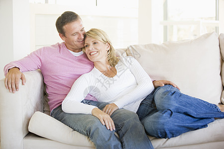 情侣在客厅放松 微笑男人女性妻子沙发团结成人伙伴休息室水平中年图片