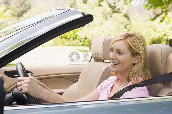 坐在可兑换汽车上的妇女笑着女性摩托车女士敞篷车水平成人微笑男性农村软顶图片