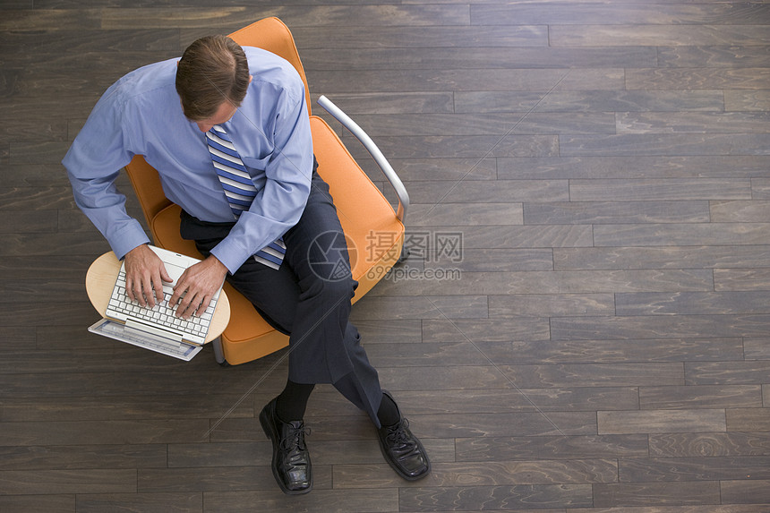 用笔记本电脑坐在室内的商务人士男人职场水平工作高架男性成人椅子大堂门厅图片