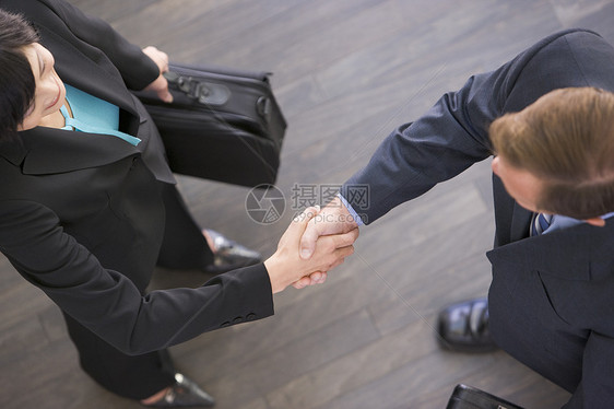 两位商务人士站在室内握手摇握手图片
