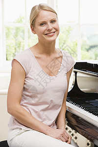 女人坐在钢琴上 笑着微笑客厅水平键盘相机乐器爱好女性音乐家庭乐趣图片