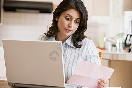 厨房用笔记本电脑的妇女技术阅读信贷危机预算信用文书账单混血儿帐户图片