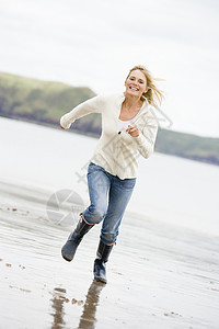 女人在海滩上欢笑海岸线微笑支撑季节海洋相机视角偏移角视图中年图片