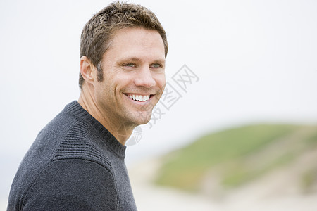 站在海滩上微笑的男人季节沉思中年大海支撑海岸线男性相机思维视角图片