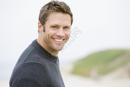 站在海滩上微笑的男人思维海岸线男性沉思视角相机季节中年大海海洋图片