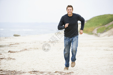 一个人在海滩上欢笑着奔跑图片