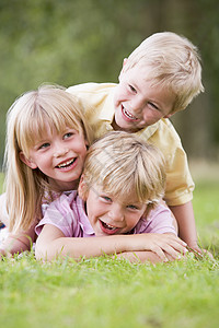 孩子微笑三名在户外玩游戏的幼儿微笑森林孩子相机小路林地公园女孩小男孩亲热农村背景