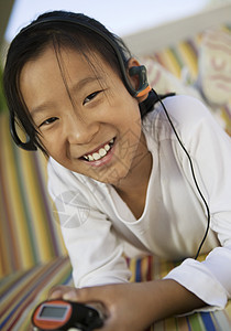 女孩听MP3播放播放器享受孩子们女性肖像场景女孩们头部情感耳机音响图片