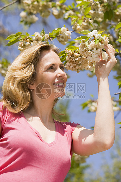 站在户外 微笑着鲜花的女子女性花朵季节农村公园图片