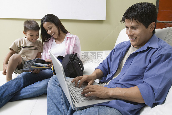 家庭使用笔记本电脑和看DVD在库奇上图片