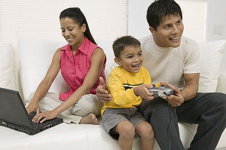 家庭玩视频游戏和在库奇使用计算机图片