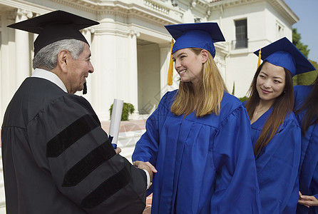 研究生 握手和获得毕业文凭习俗验收行政长袍成年人学术界校友活动服饰毕业典礼图片