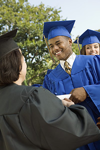 研究生 握手和获得毕业文凭庆祝校友学术界验收种族衣服毕业典礼非裔成年人成就图片