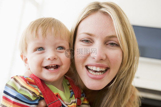 母亲在起居室抱着婴儿微笑水平照顾儿童相机妈妈儿子两个人女性男性家长图片