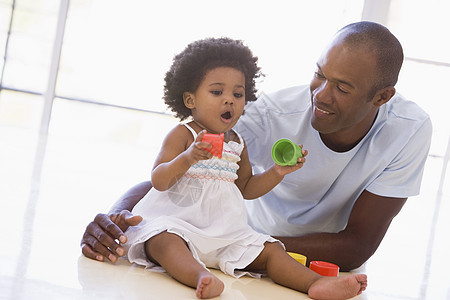 父亲和女儿在室内玩耍 微笑塑料婴儿孩子杯子客厅塑料杯爸爸家庭女性女孩图片