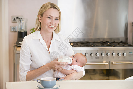 以咖啡微笑的咖啡在厨房喂育婴儿的母亲新生女朋友喝咖啡牛奶家庭婴儿照顾女士女孩享受图片