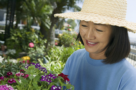 妇女持花女性时间日常生活花朵空闲园丁园艺享受培育场景图片