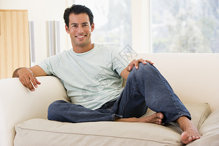 坐在客厅里的人微笑着男性休息室相机长椅水平沙发长度图片