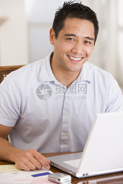 餐室里的男人笑着用笔记本电脑图片