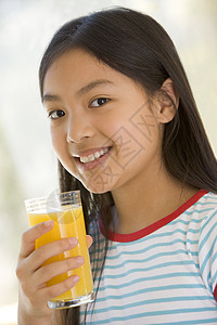 室内年轻女孩在喝橙汁时微笑果汁孩子食品儿童食物一个女孩孩子们混血儿图片