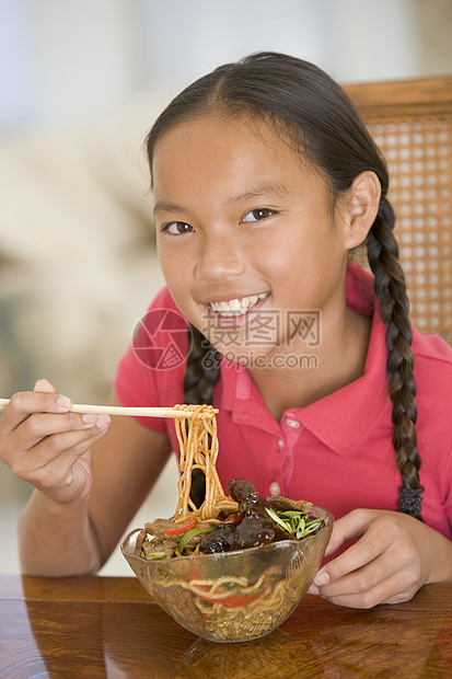 饭厅的年轻女孩在吃中国食物时微笑着笑中餐美食一个女孩孩子们刀具儿童食品用具餐具混血儿图片