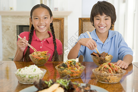 两个小孩在饭厅吃中国菜 笑着笑着小男孩家庭水平食品外卖美食孩子们孩子姐姐男生图片