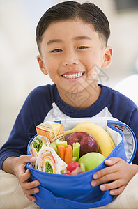 室内年轻男孩带着满满的午餐 微笑着笑容图片