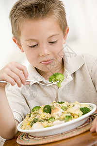 年青男孩在室内吃食物图片