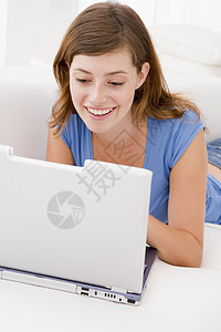 带着笔记本电脑微笑的客厅妇女女性家庭上网休息室女子技术长度互联网图片