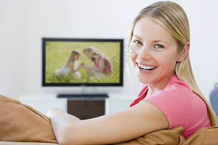 在客厅里看电视笑着的女子家庭沙发屏幕女性微笑电视纯平水平技术平面图片